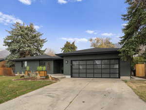 View of front of house with brick siding, driveway, and an attached garage