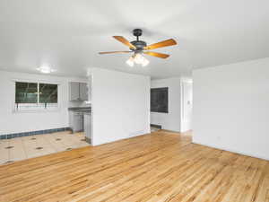 Unfurnished living room featuring light wood-type flooring and ceiling fan