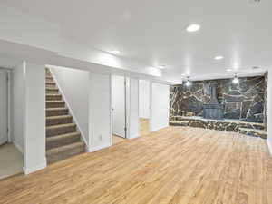Finished below grade family room featuring a wood stove, light flooring, and recessed lighting