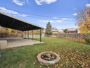 Fenced backyard featuring a fire pit, a patio, and a mountain view