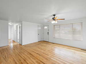 Unfurnished living room featuring light wood finished floors and a ceiling fan