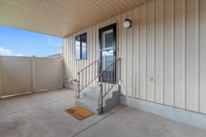 Home back entrance featuring board and batten siding and a large private patio area