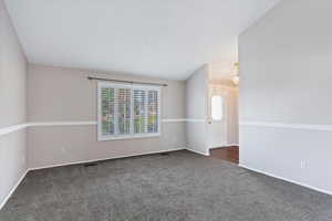 Empty room with dark carpet and baseboards