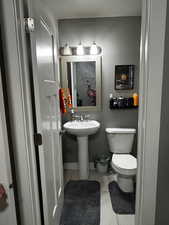 Half bath featuring light tile patterned floors and toilet