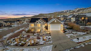 View of front of house with a residential view, driveway, stone siding, solar panels, and a garage
