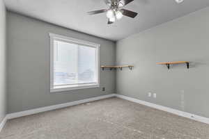 Spare room with carpet, ceiling fan, and a textured ceiling