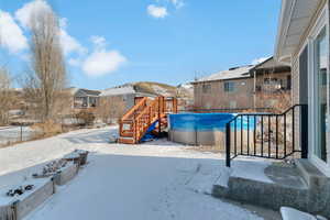 Snow covered playground with stairway, an outdoor pool, and a residential view