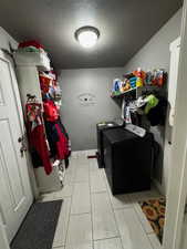 Laundry area featuring a textured ceiling and separate washer and dryer