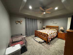 Bedroom featuring a raised ceiling, carpet floors, ceiling fan, and recessed lighting