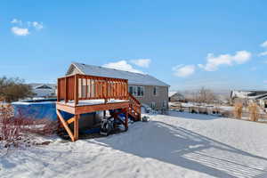 Snow covered property featuring a deck and stairs