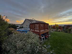 Back of property featuring a wooden deck and a yard