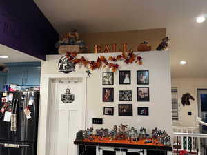 Detailed view of recessed lighting, freestanding refrigerator, and a bar