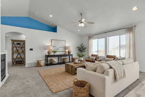 Living area featuring vaulted ceiling, ceiling fan, recessed lighting, and light carpet