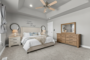 Bedroom featuring a raised ceiling, carpet, ceiling fan, and recessed lighting
