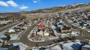 Snowy aerial view featuring a residential view and a mountain view