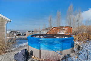Snow covered pool featuring a grill and a deck