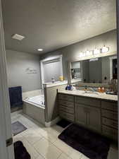 Full bathroom with vanity, a textured ceiling, and a garden tub