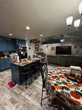 Dining space featuring a textured ceiling, a chandelier, recessed lighting, light wood-style floors, and ceiling fan