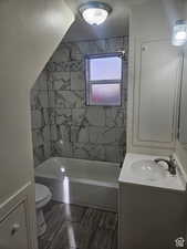 Full bath with vanity, wood tiled floors, bathtub / shower combination, and a textured ceiling