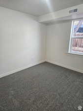 Carpeted empty room featuring baseboards