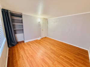 Unfurnished bedroom featuring a textured ceiling, light wood finished floors, and a closet