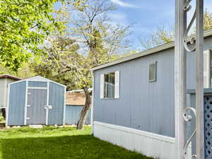 View of home's exterior with a yard and a shed