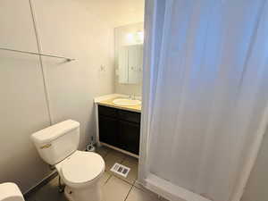 Bathroom with light tile patterned floors, a stall shower, and vanity