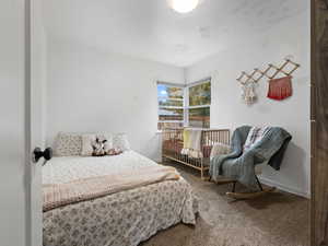 Bedroom featuring carpet flooring and baseboards