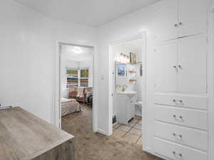 Corridor featuring light colored carpet and light tile patterned flooring