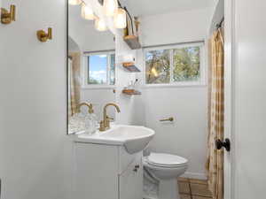 Bathroom with curtained shower, vanity, and light tile patterned floors