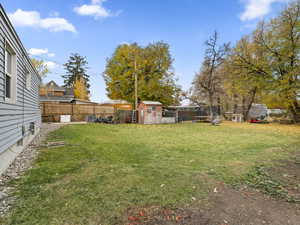Fenced backyard featuring a shed