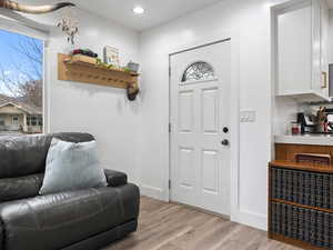 Entrance foyer with light wood-style flooring and recessed lighting