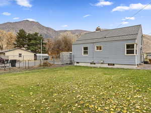 Back of house featuring a mountain view, a chimney, and roof with shingles