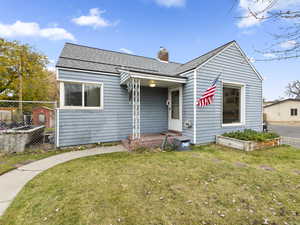 Bungalow featuring a shingled roof and a chimney