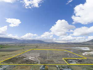 Overview of rural landscape with a mountainous background and property parcel outlined