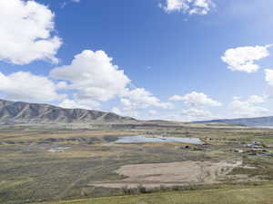 View of mountain backdrop with a nearby body of water and rural landscape