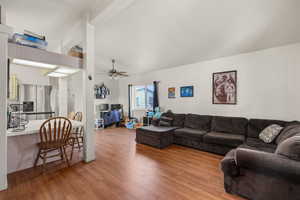 Living area featuring light wood-type flooring, a ceiling fan, and lofted ceiling