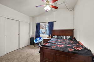 Bedroom with light colored carpet, a closet, and a ceiling fan