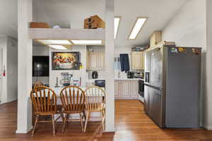 Kitchen with stainless steel refrigerator with ice dispenser, light countertops, light wood-style floors, white range with gas stovetop, and dishwasher