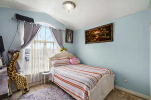 Bedroom with carpet and lofted ceiling