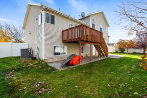 Rear view of property with a patio, a fenced backyard, a wooden deck, and stairs