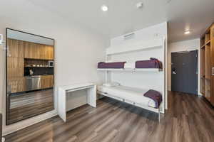 Bedroom featuring dark wood-type flooring and baseboards