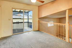 Carpeted empty room featuring a ceiling fan