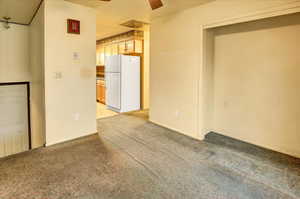 Unfurnished room with a ceiling fan and light carpet