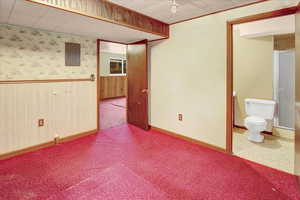 Spare room featuring wallpapered walls, wood walls, wainscoting, and electric panel