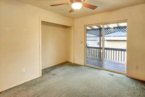 Empty room featuring carpet and a ceiling fan