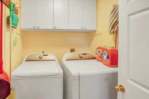 Washroom with cabinet space and washing machine and dryer