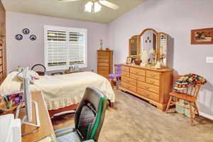 Bedroom with light colored carpet and a ceiling fan