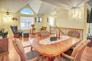 Dining area with hardwood / wood-style flooring and lofted ceiling