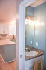 Half bathroom featuring vanity and light wood-style flooring